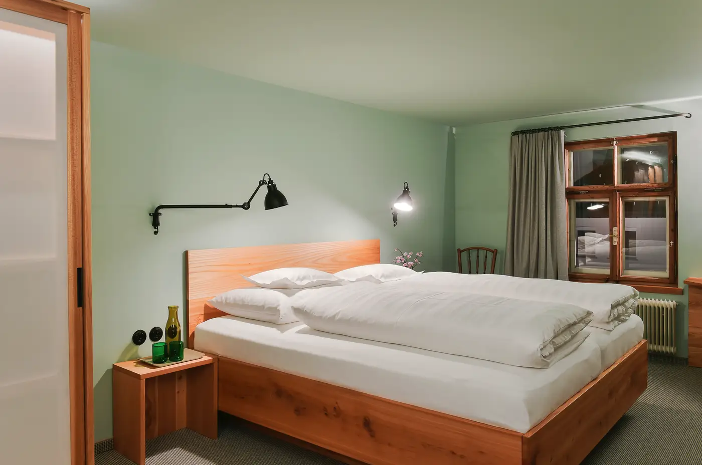 Doppelzimmer mit Bett aus Ulmenholz und Leselampen